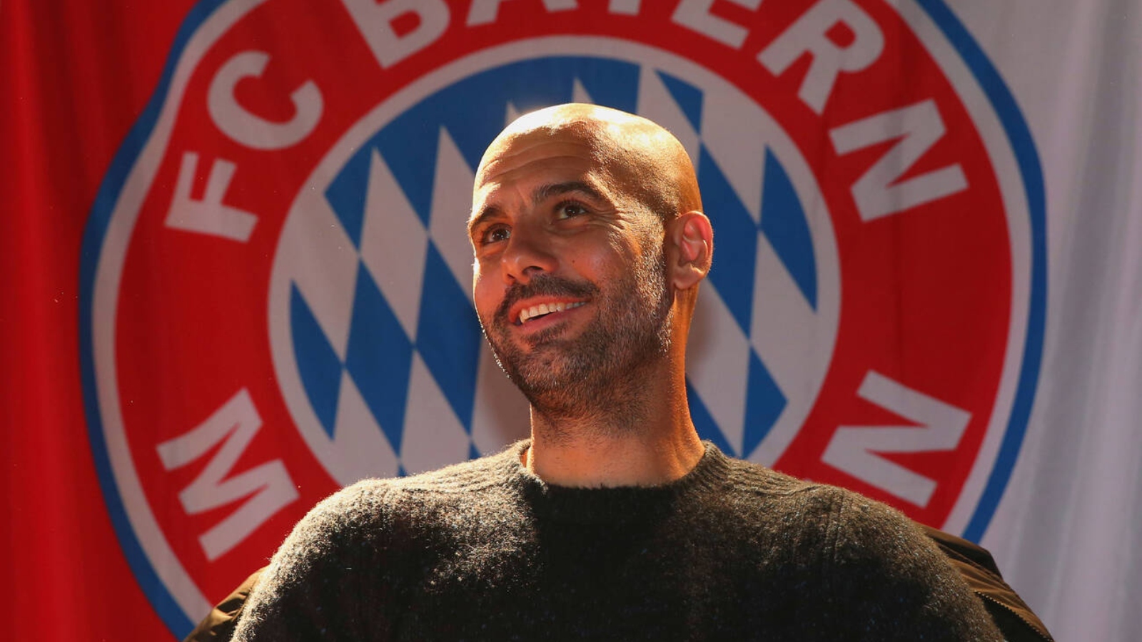 Josep "Pep" Guardiola, head coach of German Football Bundesliga Club FC Bayern Munich in front of the club logo