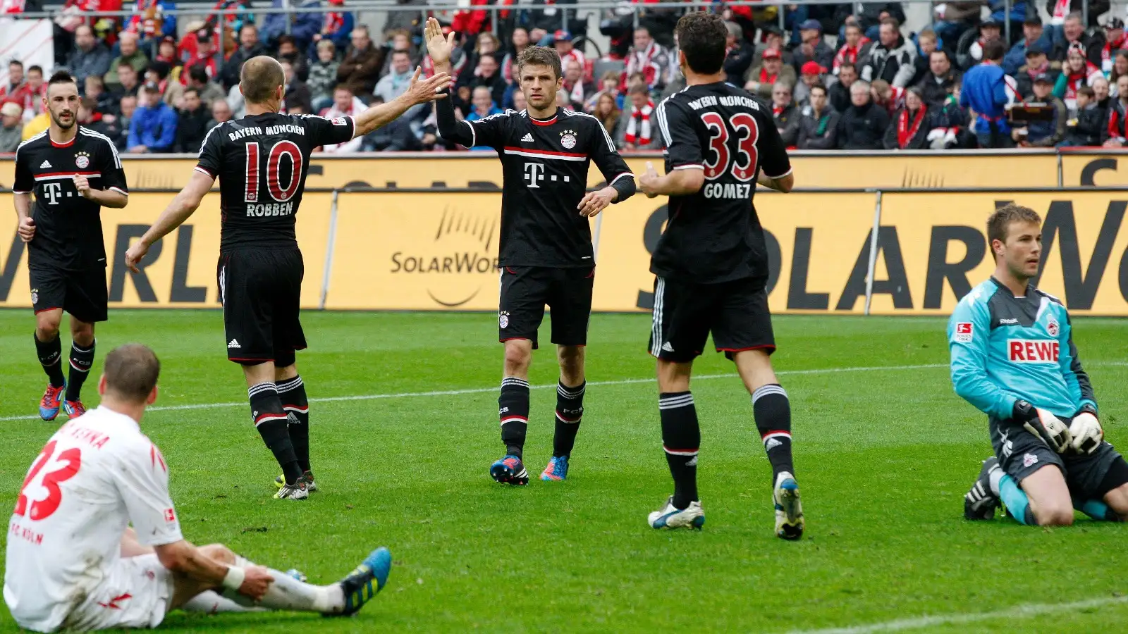 Munich's Thomas Mueller, center, celebrates his team's opening goal as Cologne's goal keeper Michael Rensing, right, looks on during the German first division Bundesliga soccer match between 1. FC Cologne and Bayern Munich in Cologne, Saturday, May 5, 2012.