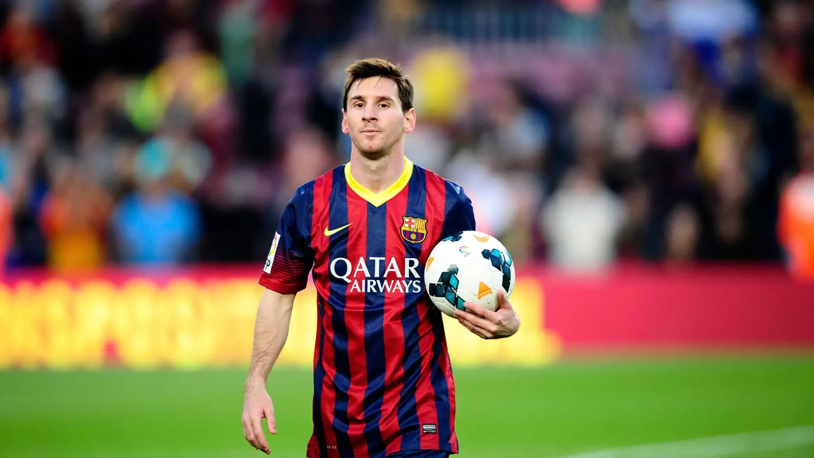 Lionel Messi celebrates with a match ball