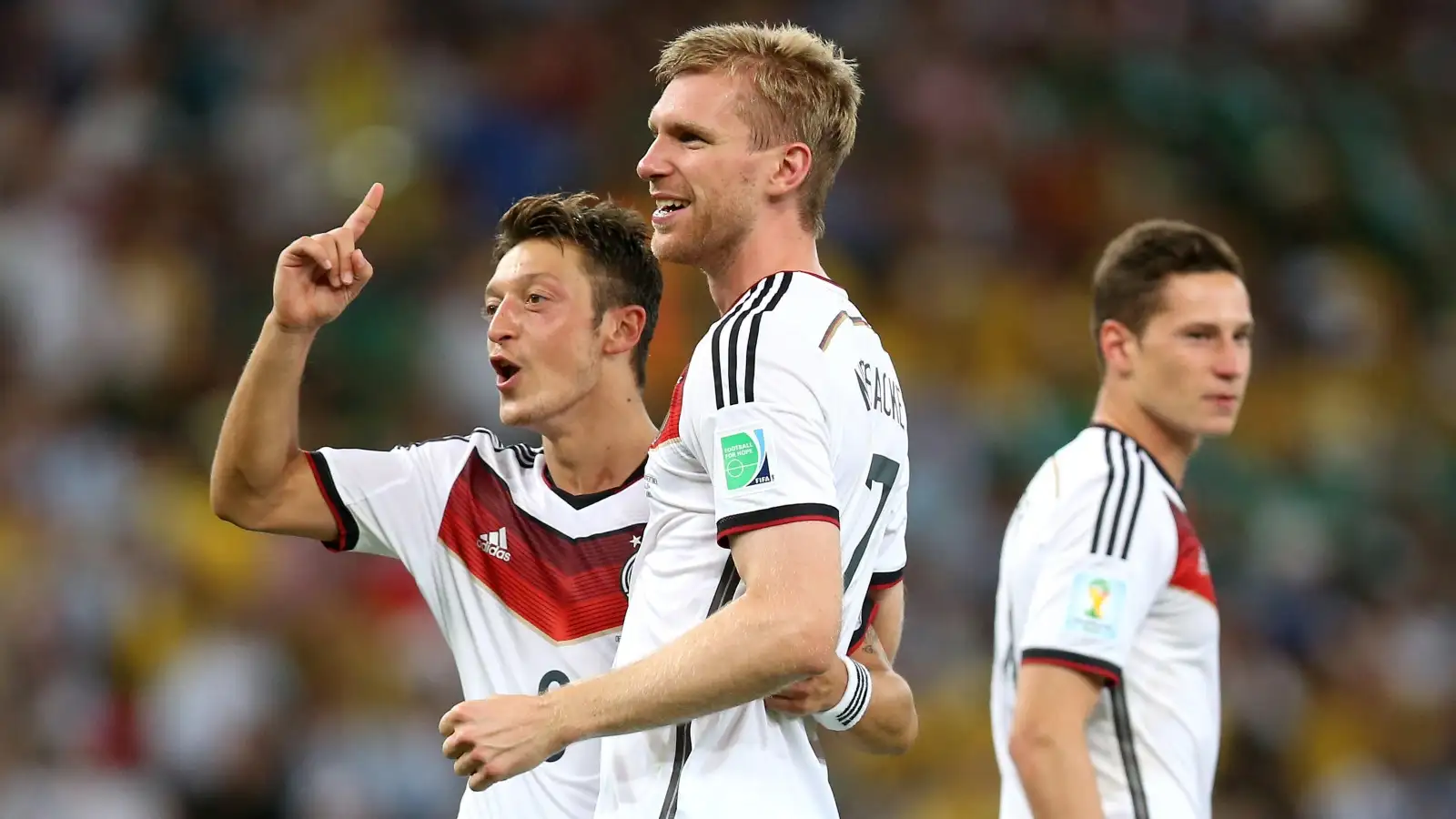 Germany's Per Mertesacker (centre) and Germany's Mesut Ozil (left) celebrate winning the World Cup after during the FIFA World Cup Final at the Estadio do Maracana, Rio de Janerio, Brazil. Arsenal.